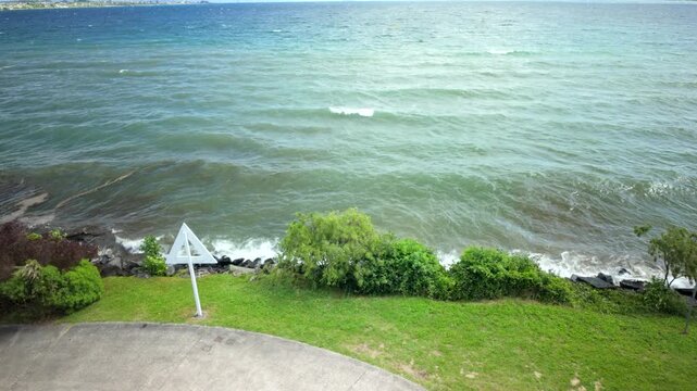 Windy Lakeshore With Green Grass And Arrow Sign
