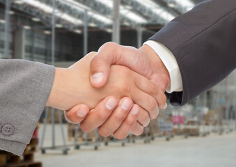 Business handshake in industrial warehouse