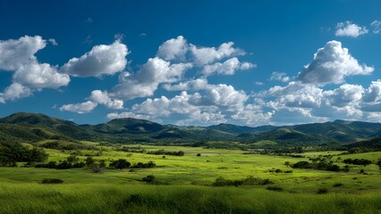 Obraz premium Panoramic view of lush green fields and rolling mountains on a perfectly clear day