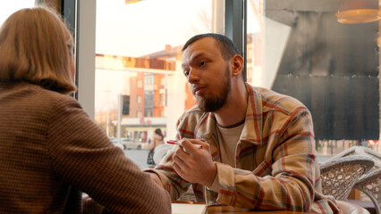 Close-up of two people in a cafe discussing plans or business ideas