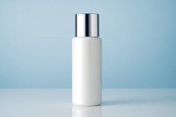 White opaque cosmetic bottle with reflective chrome silver cap standing on a bright surface against a soft light blue background mockup