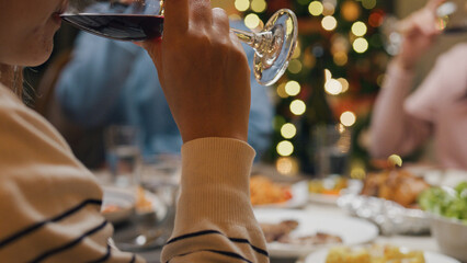 Group of Asia colleague gathering New year holidays party together. Close-up Happy friends group drink glasses of wine start eat christmas dinner at home in evening, celebration and people concept.