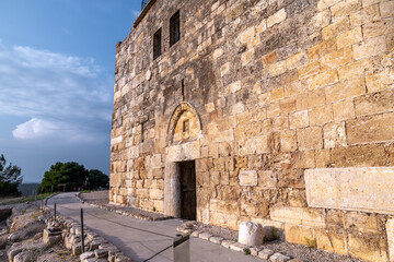 Preserved stone fortification with arched doorway in Zippori National Park, Galilee, Israel. Weathered limestone blocks glow in warm evening light along a quiet path