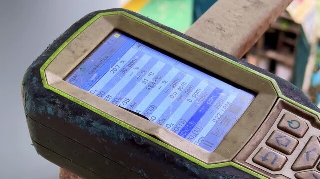 Handheld gas monitor screen showing environmental data, perfect for workplace safety, hazard detection, and industrial scenes.