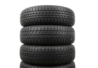 Stack of four pristine, matte black radial car tires, detailed tread patterns visible, set against a transparent studio background using low angle commercial lighting. Concept for automotive