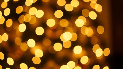 Golden bokeh lights in a dark background creating a warm and cozy atmosphere with blurred circles of light