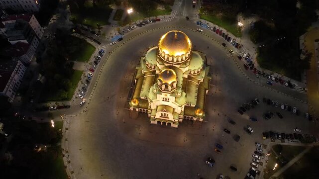 Aerial night view of Bulgaria's capital Sofia. Iconic building. View of the Cathedral of St. Alexander Nevsky at nightfall, the largest church in the Balkans. Lateral movement. Streets and parks. 4K