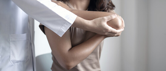 Female physiotherapists provide assistance to woman patients with elbow injuries examine patients in rehabilitation centers. Physiotherapy concepts