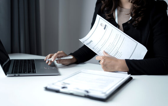 Business woman employer holding resume hiring recruit looking cv resume to hire candidates, analyzing information before job interview. Recruitment concepts