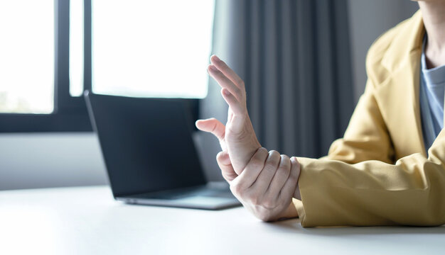 Woman hand with wrist pain numbness and pain in the palm of the hand has pain and tingling in the nerve endings This is a side effect of sitting and working for a long time on a laptop at the office