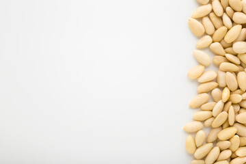 Almond nuts on light gray table background. Closeup. Empty place for text. Top down view.