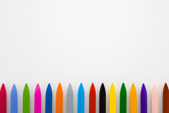 Row of colorful wax crayons on light gray table background. Closeup. Empty place for text. Top down view. - Powered by Adobe