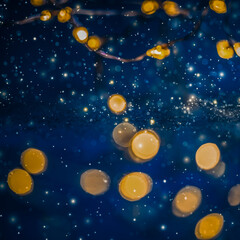 Naklejka premium Abstract festive bokeh lights on dark blue background with glowing golden particles