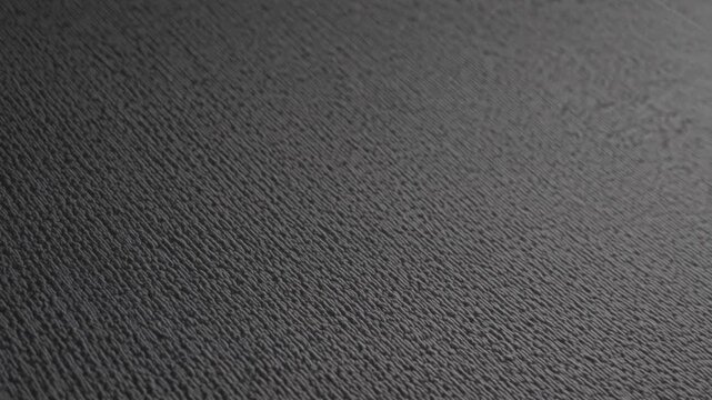 Close-up examination of textured surface showcasing detailed patterns and shadows in low light