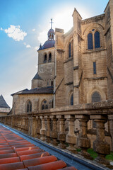 Historic stone facade and bell tower of an old cathedral with a rooftop balustrade