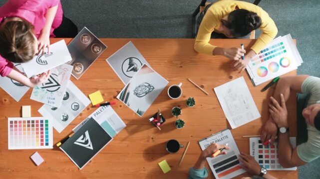 Top view of manager writing idea on sticky notes and explain idea about web design. Professional marketing team or programmer brainstorming idea while looking at tablet with color palette. Symposium.