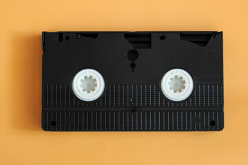 Retro vhs video cassette tape on orange background