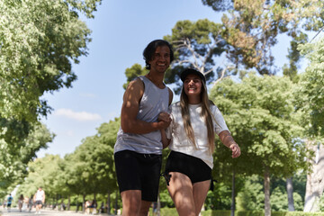 Fototapeta premium Happy couple holding hands and walking in a park