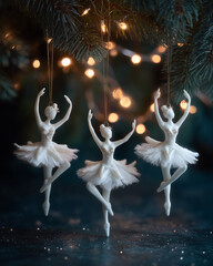 Three white ballerina christmas tree ornaments hang from the branches of an evergreen, with their arms raised in ballet poses and wearing tutus, against a dark background with twinkling lights