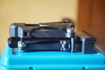 Side view of a compact folding drone and battery module prepared for outdoor flight.