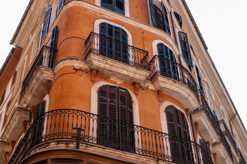 Corner of a Traditional Orange and Black Residential Building with Balconies in Palma Old Town