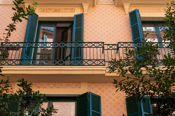 Warm Peach and Green Residential Facade with Patterned Walls and Balcony, Palma de Mallorca