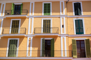 Row of Traditional Mediterranean Residential Facade with Yellow Walls and Green Shutters, Palma