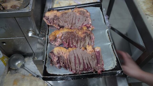 Butcher preparing sliced t bone steaks in a commercial kitchen