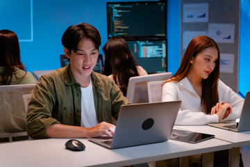 Asian software engineer or programmer team working late in development office,problem solving or algorithm of ai assistant helping for work.software developer,digital technology security concept