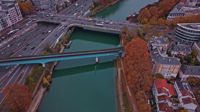 Drone advances over Marne River and railway bridge as a train crosses near Paris.