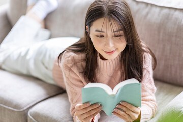 ソファで読書をする女性