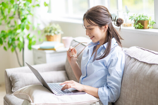 部屋でパソコンを見る女性