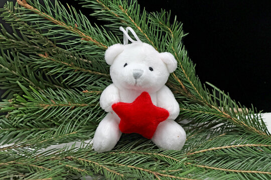 petite peluche ourson dans les aiguilles du sapin