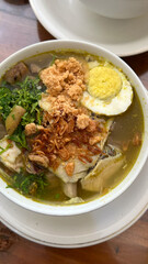 rice with chicken soto and egg. soto ayam served with white rice, Indonesian traditional chicken soup