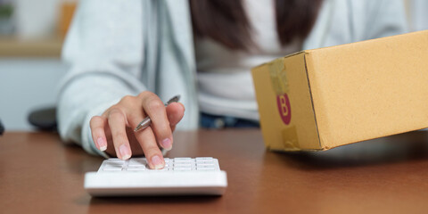 E-commerce Management: Calculating Costs with Package on Desk