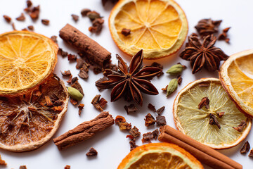 Mixed dried winter spices and citrus fruit slices flat lay isolated on white background. Top view of cinnamon, star anise and ingredients for mulled wine