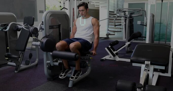 Man performing controlled leg extensions in gym, gripping handles and initiating reps for strength