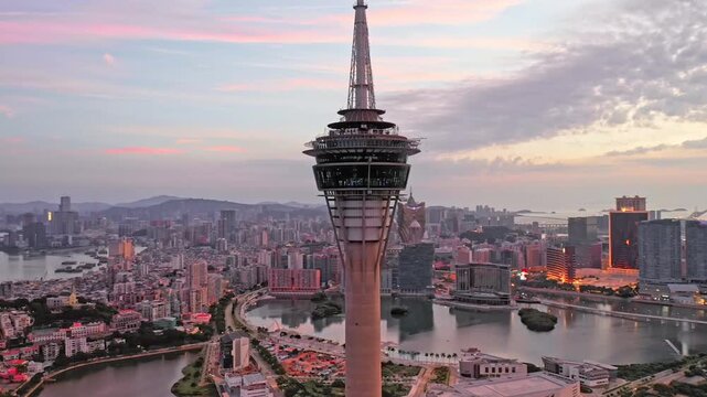 Aerial of a sky tower and a cityscape with high rise buildings at sunset