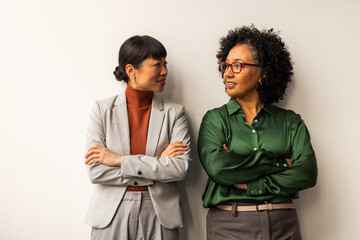 Two Professional Women Colleagues Having a Friendly Conversation in an Office Setting