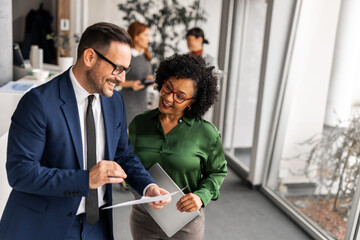 Coworkers Collaborating and Smiling in Modern Office Setting