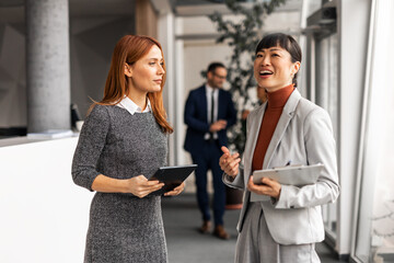 Two Professional Women Discussing Work in a Modern Office Setting