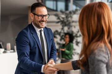 Business Professionals Shaking Hands in Modern Office Setting