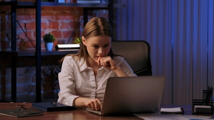 Focused Woman Working Late on Laptop in Office Environment