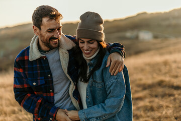Happy couple enjoying autumn outdoors embracing love