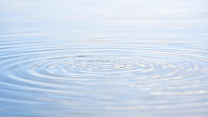 Close-up of concentric circular water ripples on a smooth light blue surface under bright high-key natural lighting with shallow depth of field