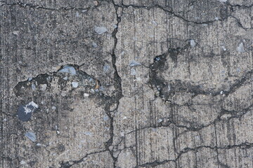Cracked Concrete Surface with Distinct Footprints and Stone Debris in Urban Landscape
