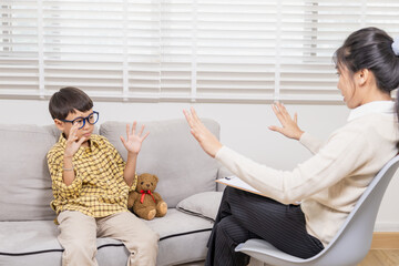 Child behavior therapy counseling, psychologist, emotion convey through gentle interaction, female therapist offers teddy bear, helping young boy express feelings, trust-building play therapy session