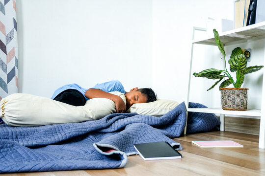 Tired Child Taking A Nap On Blue Mattress At Home After Studying, Surrounded By Scattered Books - Powered by Adobe