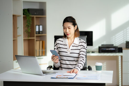 Business woman or financial data analysts working with alculator and laptop computers and data graphs together. - Powered by Adobe