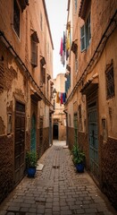 Fototapeta premium Enchanting alleyway with historic architecture and hanging laundry in a moroccan medina